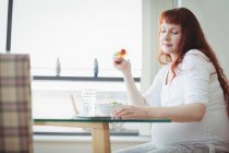 Беременная женщина с помощью цифровых таблеток во время салата дома — стоковое фото