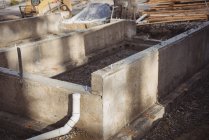 Бетонный фундамент и дренажные трубы на строительной площадке — стоковое фото
