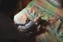 Mother playing with cute baby in bedroom at home — Stock Photo