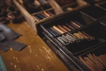 Divers portefeuilles en cuir dans une caisse en acier en atelier — Photo de stock