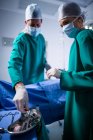 Male and female surgeons performing operation in operation theater of hospital — Stock Photo