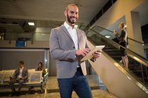 Uomo d'affari che utilizza tablet digitale in aeroporto — Foto stock