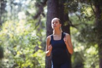 Belle femme jogging en forêt — Photo de stock