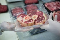 Butchers packing raw meat in plastic packaging tray at meat factory — Stock Photo