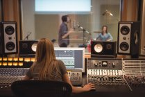 Rear view of audio engineer using sound mixer in recording studio — Stock Photo