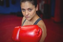 Впевнена жінка-боксер, що виконує позицію боксу в фітнес-студії — стокове фото