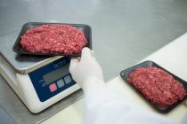 Metzger wägt Pakete mit Hackfleisch in Fleischfabrik — Stockfoto