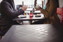 Mittelteil des Paares hält Kaffeetassen im Restaurant — Stockfoto