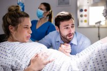 Homem reconfortante mulher grávida durante o trabalho de parto no hospital — Fotografia de Stock