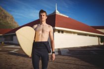 Surfista premuroso in piedi con tavola da surf sulla spiaggia — Foto stock