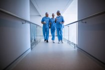 Хирурги взаимодействуют друг с другом в больничном коридоре — стоковое фото