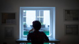 Visão traseira da mulher olhando através da janela no café — Fotografia de Stock