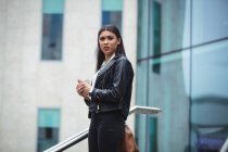 Продумана жінка стоїть за межами офісної будівлі — стокове фото