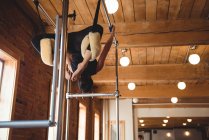Flexible woman practicing pilates in fitness studio — Stock Photo