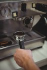 Hand of man holding portafilter under coffee machine in coffee shop — Stock Photo