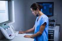 Krankenschwester macht sich Notizen im Röntgenraum im Krankenhaus — Stockfoto