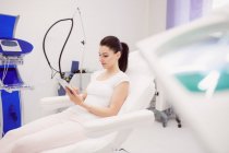 Mulher bonita usando tablet digital na clínica — Fotografia de Stock