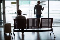 Вид ззаду бізнесменів в зоні очікування в терміналі аеропорту — стокове фото