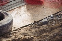 Close-up of metallic net and tyre at construction site — Stock Photo
