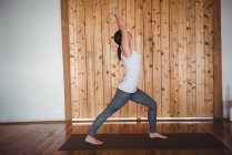 Frau praktiziert Yoga im Fitnessstudio, Seitenansicht — Stockfoto