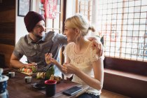 Couple interacting with each other while having sushi in restaurant — Stock Photo