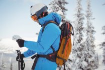 Skifahrer steht und schaut auf die Karte in verschneiter Landschaft — Stockfoto