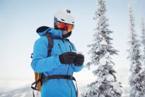 Esqui usando telefone celular em montanhas cobertas de neve — Fotografia de Stock