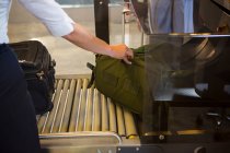 Женский персонал проверяет багаж пассажиров на транспортерной ленте в аэропорту — стоковое фото