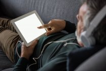 Uomo che ascolta musica su tablet digitale a casa — Foto stock