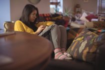 Femme utilisant montre intelligente dans le salon à la maison — Photo de stock