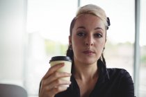 Retrato de mulher segurando copo de café descartável no café — Fotografia de Stock