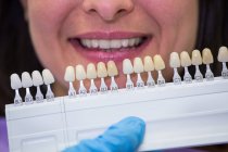 Dentista examinando paciente femenina con tonos de dientes en clínica dental - foto de stock