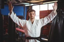 Karate player standing with arms spread in fitness studio — Stock Photo