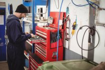 Mechaniker sortiert Werkzeuge in Werkzeugkasten in Reparaturwerkstatt — Stockfoto