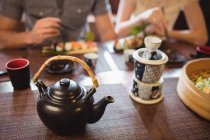Teekanne und Becher auf dem Esstisch im Restaurant — Stockfoto