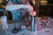 Bartender adicionando gema de ovo enquanto prepara bebida no balcão no bar — Fotografia de Stock