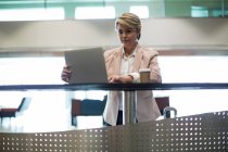 Empresária usando laptop na área de espera no terminal do aeroporto — Fotografia de Stock