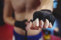 Mid section of boxer wearing black strap on wrist in fitness studio — Stock Photo