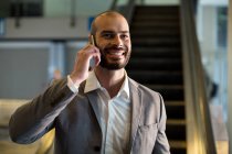 Businessman talking on mobile phone at airport — Stock Photo