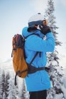 Вид сбоку на лыжи, говорящие по мобильному телефону — стоковое фото
