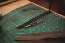 Кожаные изделия и рабочие инструменты на столе в мастерской — стоковое фото