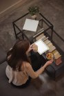 Donna con tablet digitale che fa colazione in soggiorno a casa — Foto stock