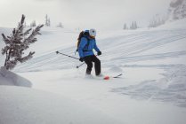 Вид збоку лижник, катання на лижах на снігу покриті гори — стокове фото