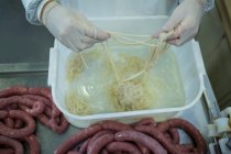 Sección media de la carnicería que procesa embutidos en la fábrica de carne - foto de stock