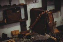 Различные кожаные принадлежности на столе в мастерской — стоковое фото