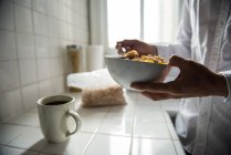 Meio da seção de homem tomando café da manhã na cozinha em casa — Fotografia de Stock