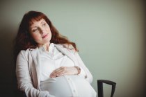 Femme d'affaires enceinte tenant ventre en fonction — Photo de stock