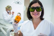 Dentista sosteniendo la luz ultravioleta de curado dental en la clínica - foto de stock