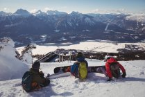 Trois skieurs se relaxent sur un paysage enneigé en hiver — Photo de stock