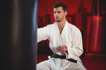 Karate player performing karate stance in fitness studio — Stock Photo